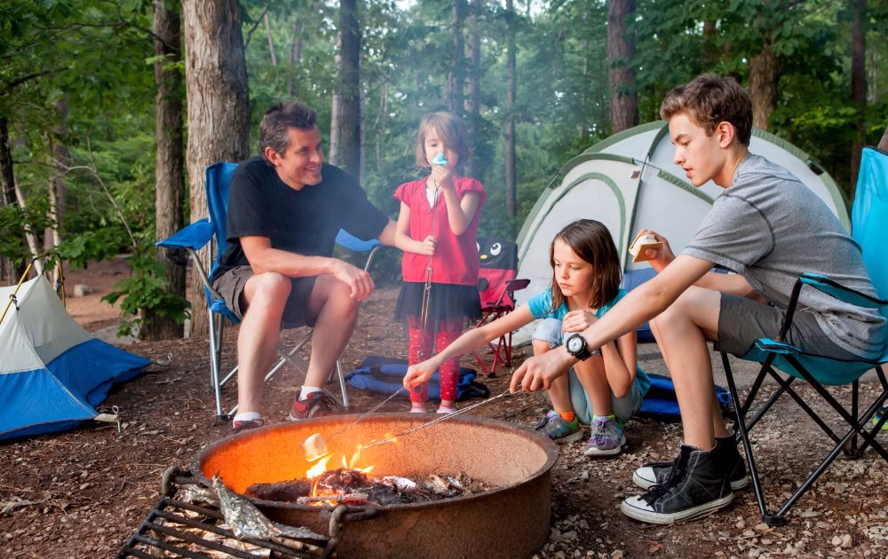 family toasting marshmallows around a campfire